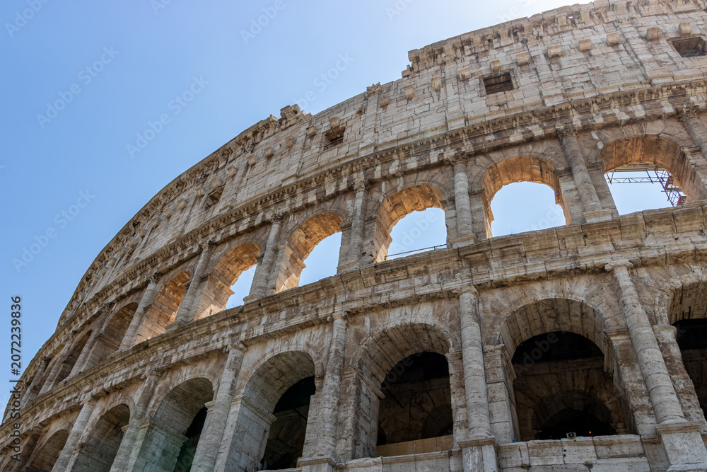 Obraz premium Famous tourist attraction of historic Colosseum amphitheatre with ancient stone arches in Rome Italy