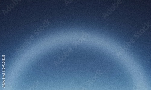 Bright glowing circular arch of soft white light appearing against a deep dark blue gradient background creating a minimalist abstract visual effect that looks elegant and very modern in style