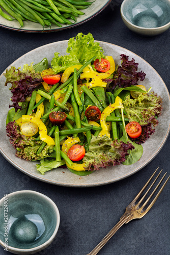 Colorful salad bowl with fresh greens and bean pods