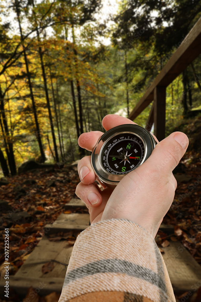 Obraz premium Tourist using compass to find way outdoors, closeup