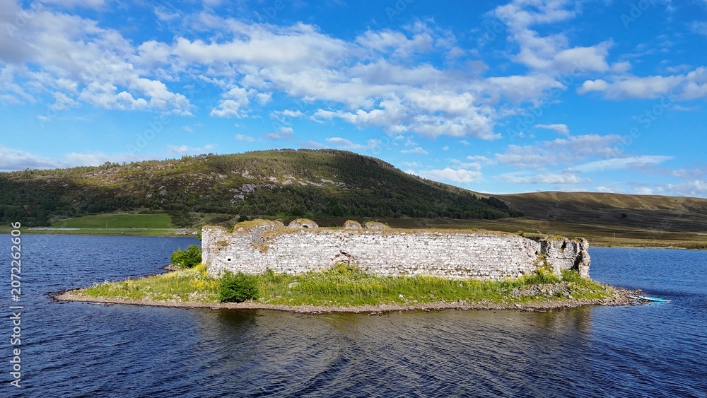 Αυτοκόλλητο From a closer aerial view, Lochindorb Castle in Scotland , scottish highlanda t reveals detailed white stone walls, island ruins, and surrounding Highland loch and rugged landscape clearly visible