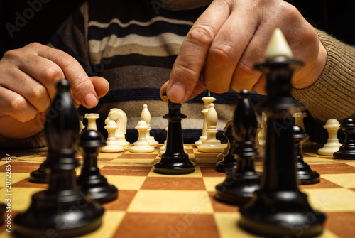Fotografia A person moves a chess piece while playing a game