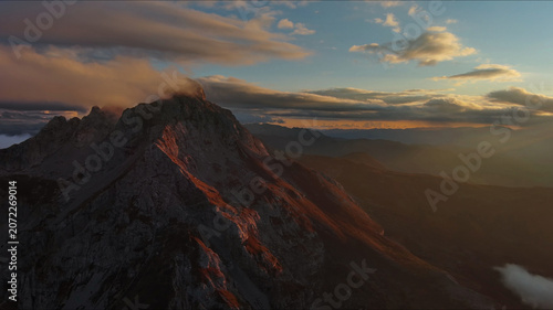 Amazing rocky mountains in clouds at sunset