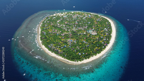 Tropical island surrounded by turquoise waters and coral reefs