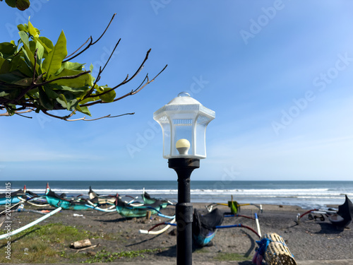Tableau sur toile Balanced Vintage Street Lamp with Leaves, Jukung Boats and Bubu Fish Trap Yeh Ga