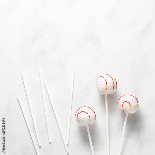 Decorated cake pops and sticks against a bright white background.