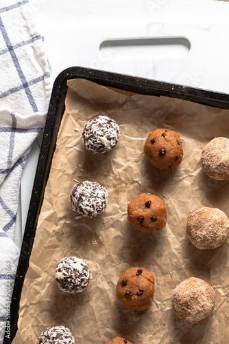 A close up of a baking sheet with rows of homemade energy balls.
