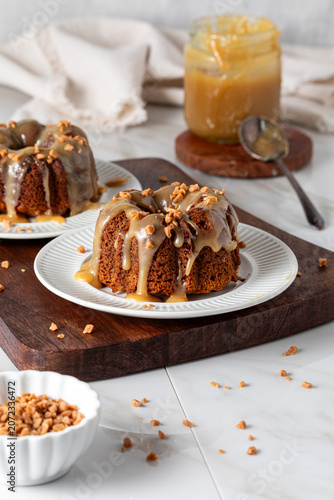 Servings of homemade sticky toffee pudding topped with toffee bits.