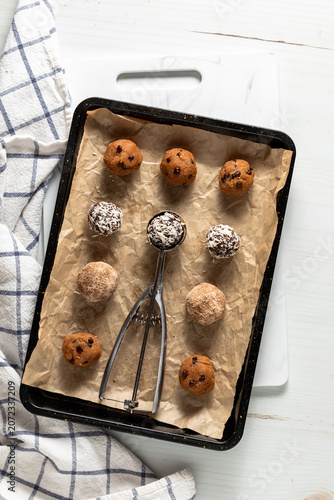 Delicious homemade high protein energy balls on a parchment lined baking sheet.