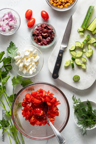 Portions of fresh ingredients for making a mediterranean salad.