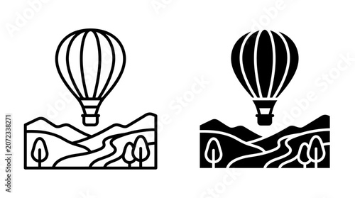 Hot air balloon floating above a scenic landscape with mountains and trees.