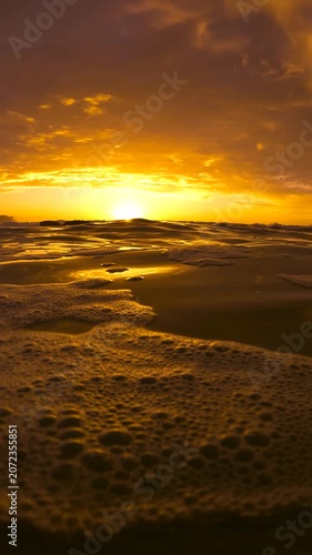 Slow motion video of a spectacular sunrise viewed from the Bogey Hole at Bronte Beach, Sydney, Australia, with calm rippling water reflecting golden morning light.