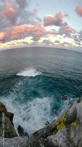 Slow motion fisheye video of Bondi Beach viewed from a coastal lookout at sunset, with calm ocean water, soft golden light, and the Sydney coastline, Australia.