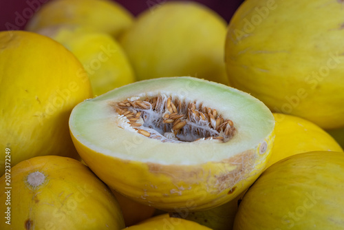 Foto Honeydew melons are stacked in a bin for sale at a supermarket