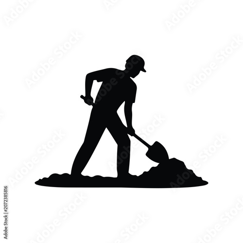 A worker uses a shovel to dig into a large pile of dirt at a construction site.