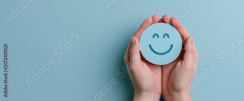 Hands holding a blue card with a smiley face icon for positive customer feedback