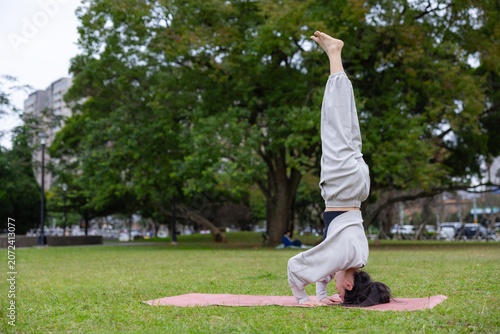 Canvastavla Woman practicing yoga headstand on grass