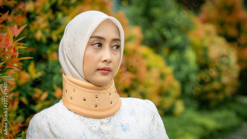 A young Asian Muslim woman wearing a Cervical Collar. Neck injury.
