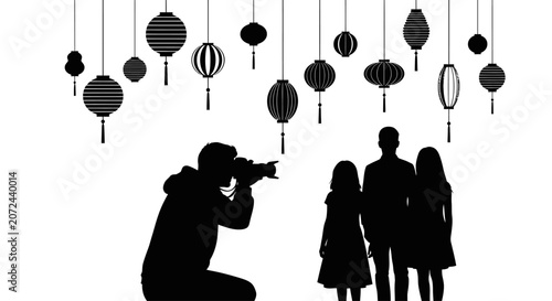 A photographer capturing a silhouette portrait of a family standing under hanging lanterns.