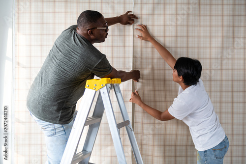 Εκτύπωση καμβά Couple installing patterned wallpaper together.