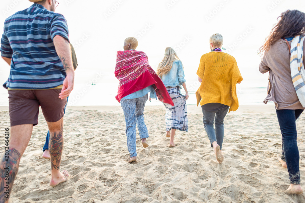 Obraz premium Friends walking on sandy beach