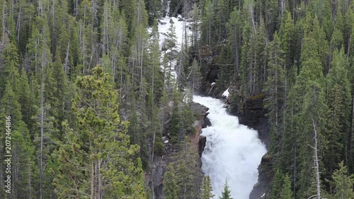 Scenic waterfall on Lake Creek flowing through the mountains beside Beartooth Highway in Wyoming