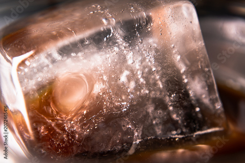 Macro Close Up Shot of a Refreshing Ice Cube Floating in a Glass of Iced Americano Black Coffee