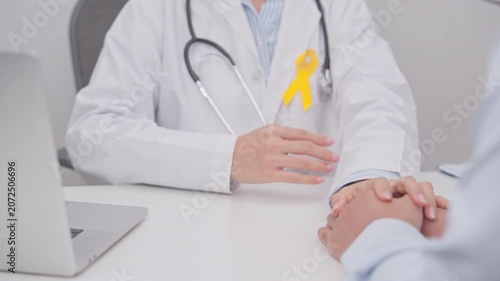 doctor holding patient hand to comfort and support with empathy for Yellow Ribbon concept of yellow September, Suicide prevention day, Childhood, July Sarcoma, bone and bladder cancer Awareness month