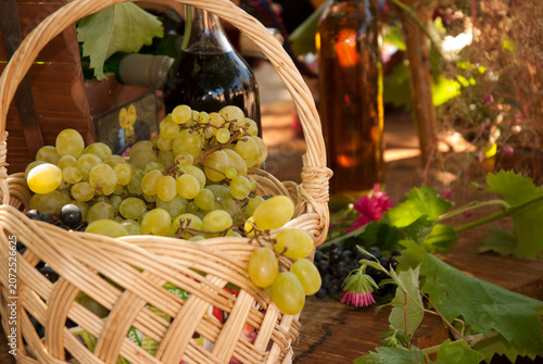 Fresh Green Grapes in Wicker Basket with Wine Bottle