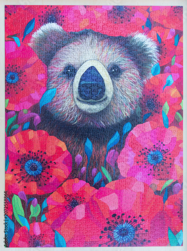 A completed jigsaw puzzle of a whimsical portrait of a koala surrounded by poppy flowers.