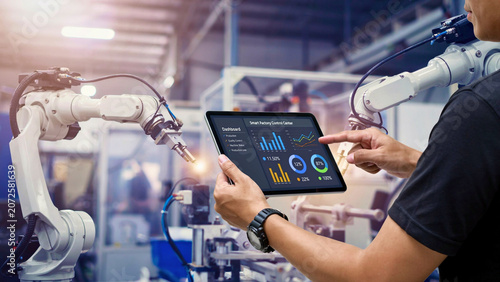 Engineer Monitoring Industrial Automation with Digital Tablet, Analyzing Production Data in Smart Manufacturing Factory Environment