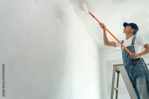 Obraz na plátně painter man, brush in hand for products to restore and paint the wall, indoor th