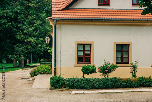 Corner of 19th century house in summer park, Europe, historic architecture, greenery