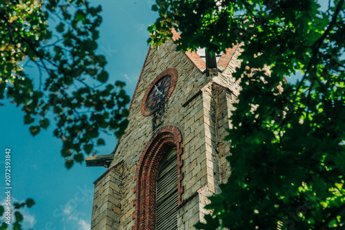 Close-up of 19th century stone tower with bell and clock, Europe, summer.