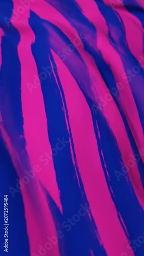 Abstract blue brush strokes on a vibrant pink fabric background