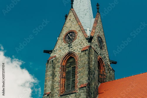 Close-up of 19th century stone tower with bell and clock, Europe, summer.