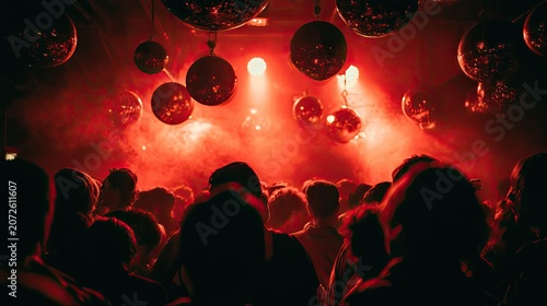 Red-lit nightclub scene with disco balls and silhouetted crowd
