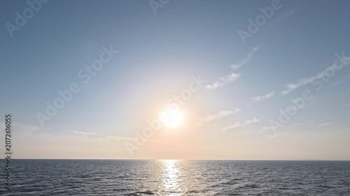 Cinematic sunset time-lapse featuring moving light clouds and gentle ocean waves
