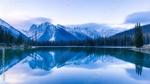 Breathtaking View of Serene Alpine Lake Reflecting Majestic Snowy Mountain Peaks During the Calm Blue Hour Twilight