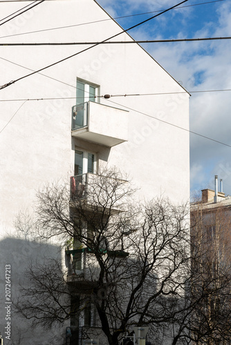 Vienna, Austria - February 12, 2023: Facade of an apartment building with a tree and shadows