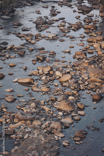 Beautiful rocky riverbed glistens under the warm light of sunset in a serene landscape filled with tranquility and nature's charm