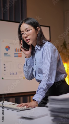 Frustrated businesswoman talking on phone working overtime