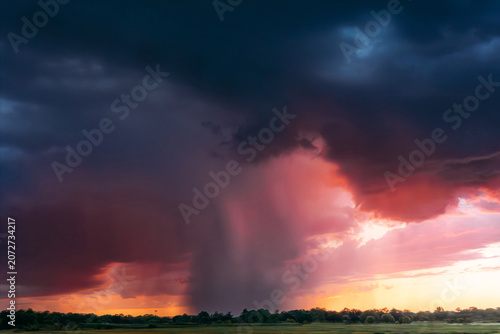 A dramatic rainstorm during a colorful sunset