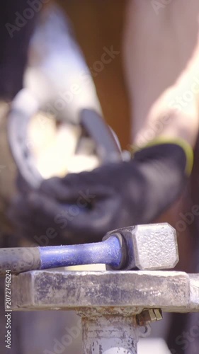 Farrier blacksmith hammer nails in to horseshoe close up