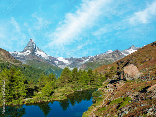 Matterhorn mountain rising above alpine lake and forests near Zermatt, Switzerland