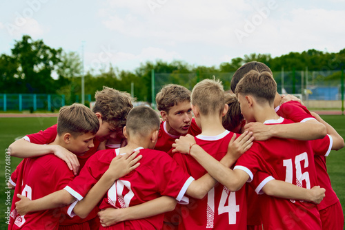 Fotografie Youth soccer team huddle before match on outdoor field