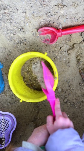 Dive into the world of creativity as a child pours sand into a bucket in this delightful video. The gentle flow of sand reflects the carefree spirit of childhood exploration and joy. Vertical 4k