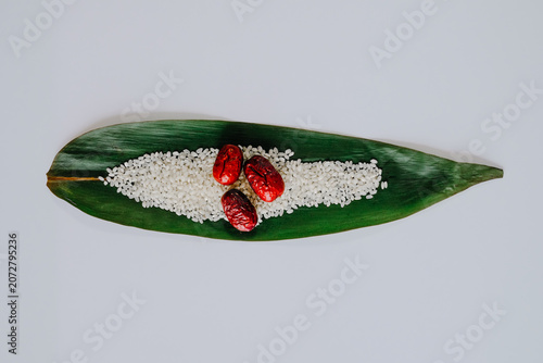Green leaf with rice grains and red berries