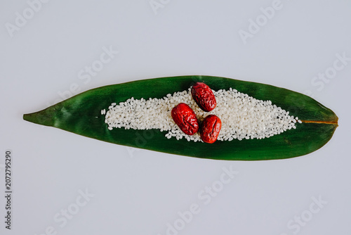 Red dates and white grains on green leaf