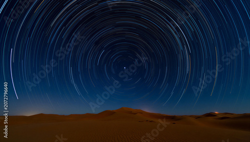 Star trails in the night sky over a desert landscape with sand dunes transparent background